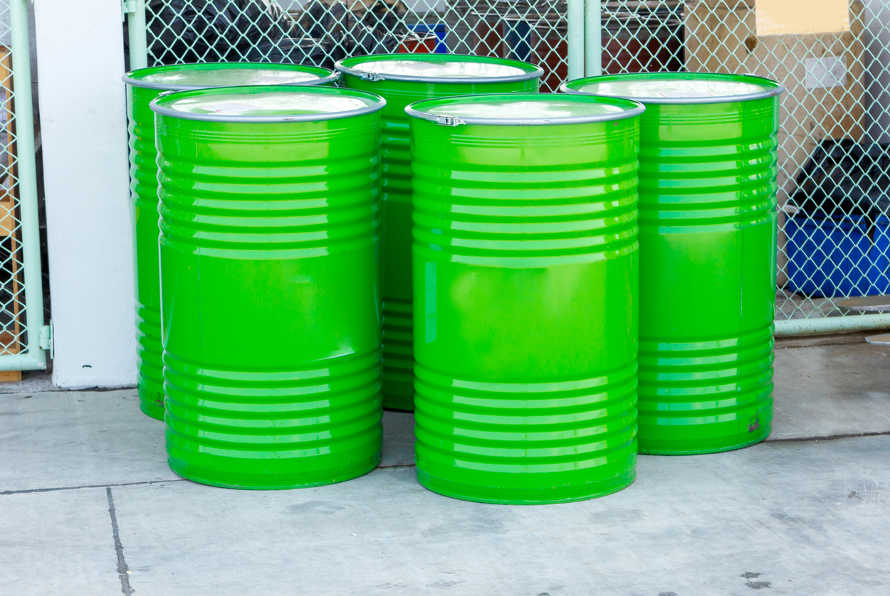 5 green 55-gallon drums for hazardous waste.